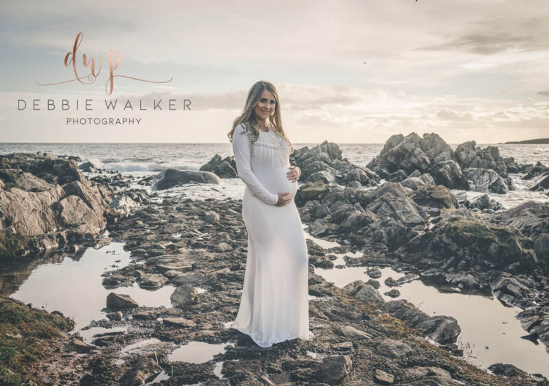 woman posing outdoors in off white maternity dress