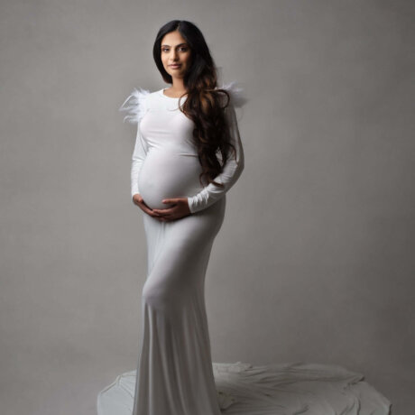 feather detail dress in white worn by expecting mother