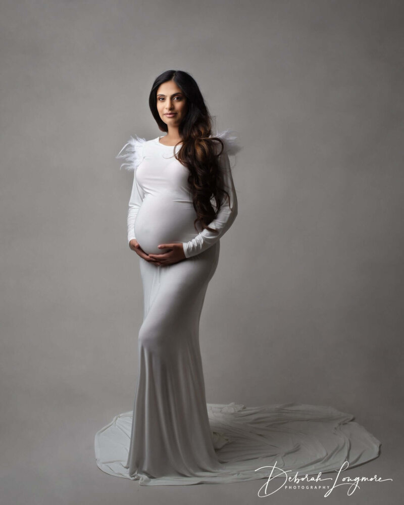 feather detail dress in white worn by expecting mother