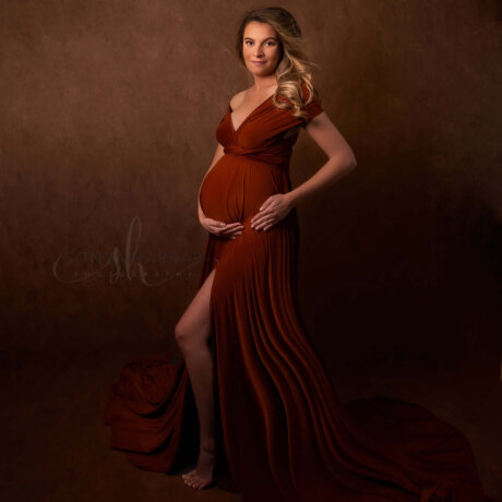 side pose of pregnant woman holding bump