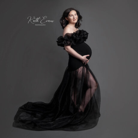Pregnant woman posed wearing black rosa amour gown