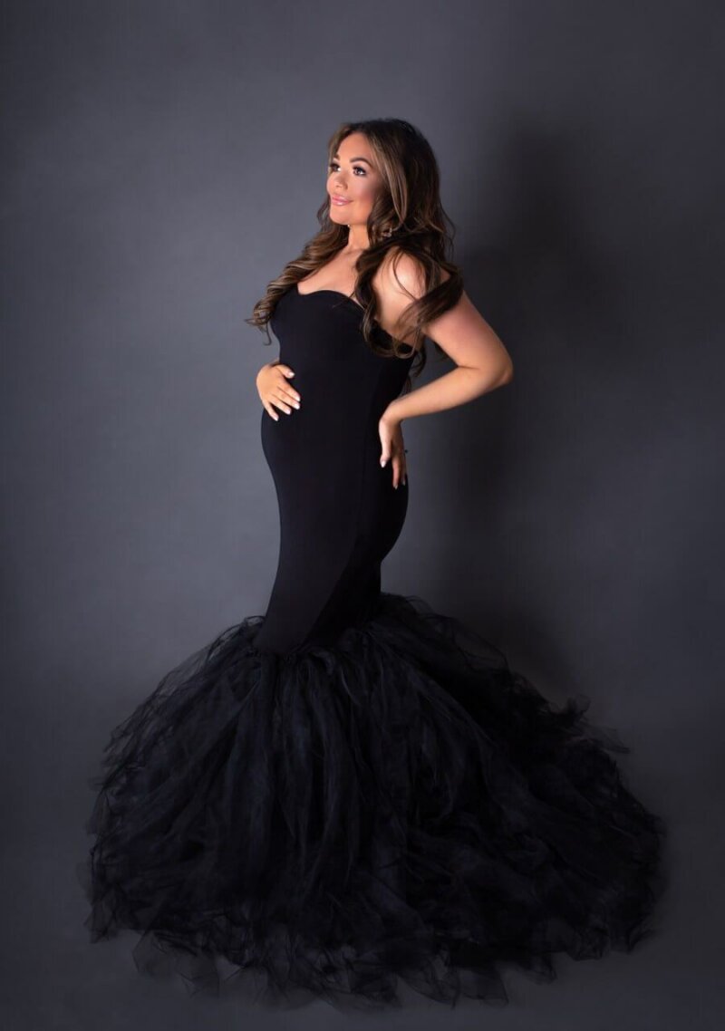 Pregnant woman wearing black ball gown by rosa amour