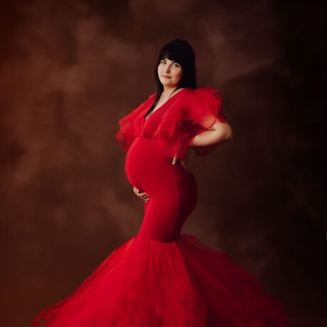 portrait of pregnant woman posing in red rosa amour gown