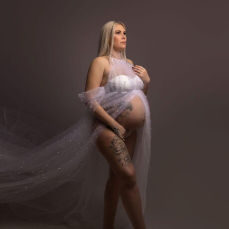 pregnant woman posed wearing a pearl tulle maternity dress