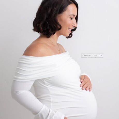 Side Posed pregnant woman wearing rosa amour white maternity bodysuit