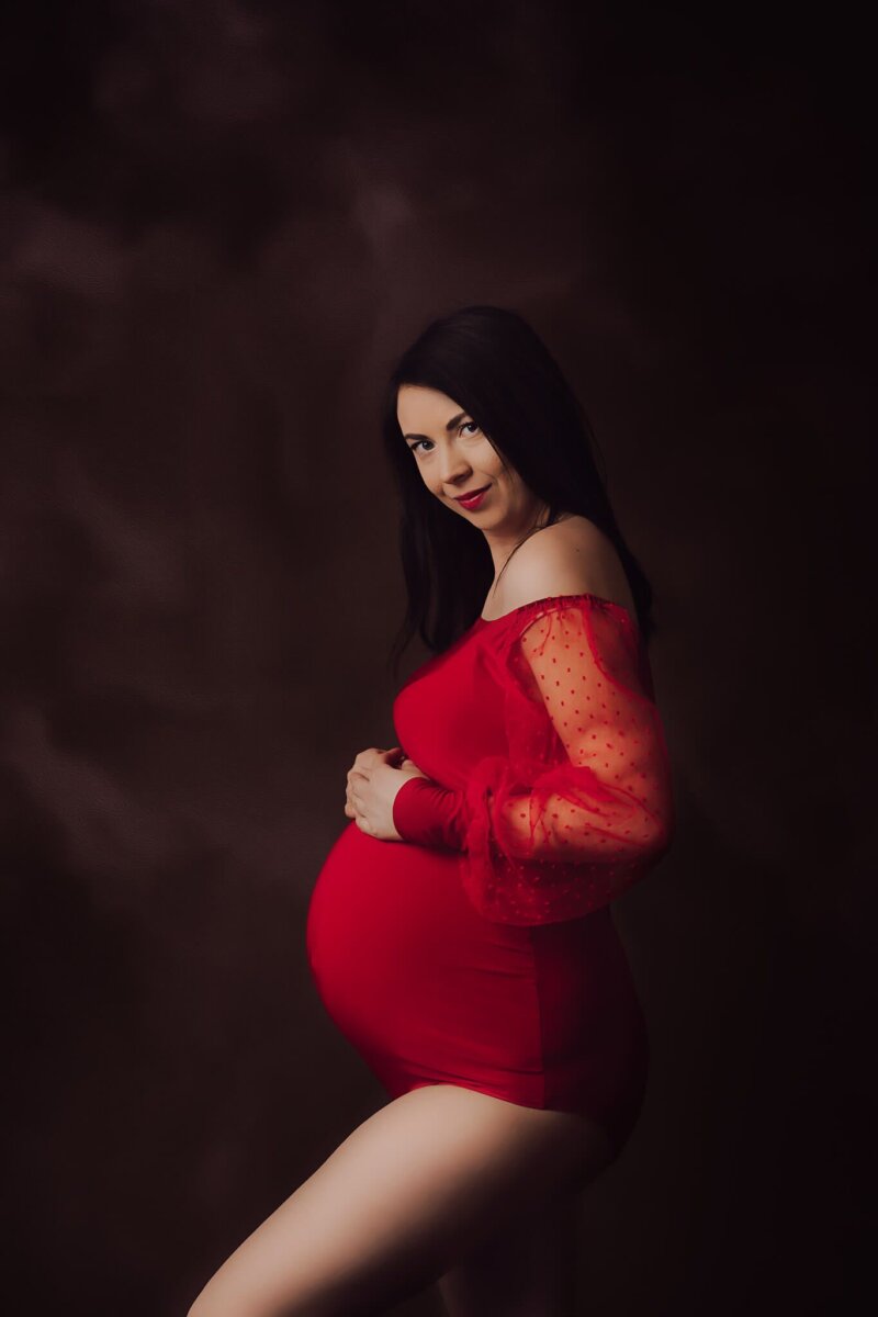 side pose of pregnant lady wearing maternity red bodysuit