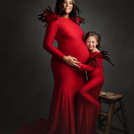 Mom and daughter wearing matching red feather shoulder dresses by rosa amour