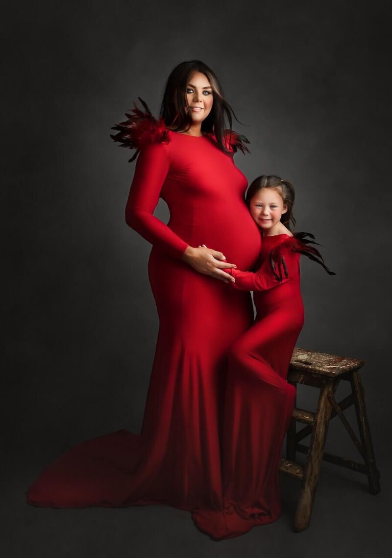 Mom and daughter wearing matching red feather shoulder dresses by rosa amour