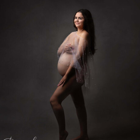 Pregnant women wearing sheer white cape/shawl with pearl details by Rosa Amour