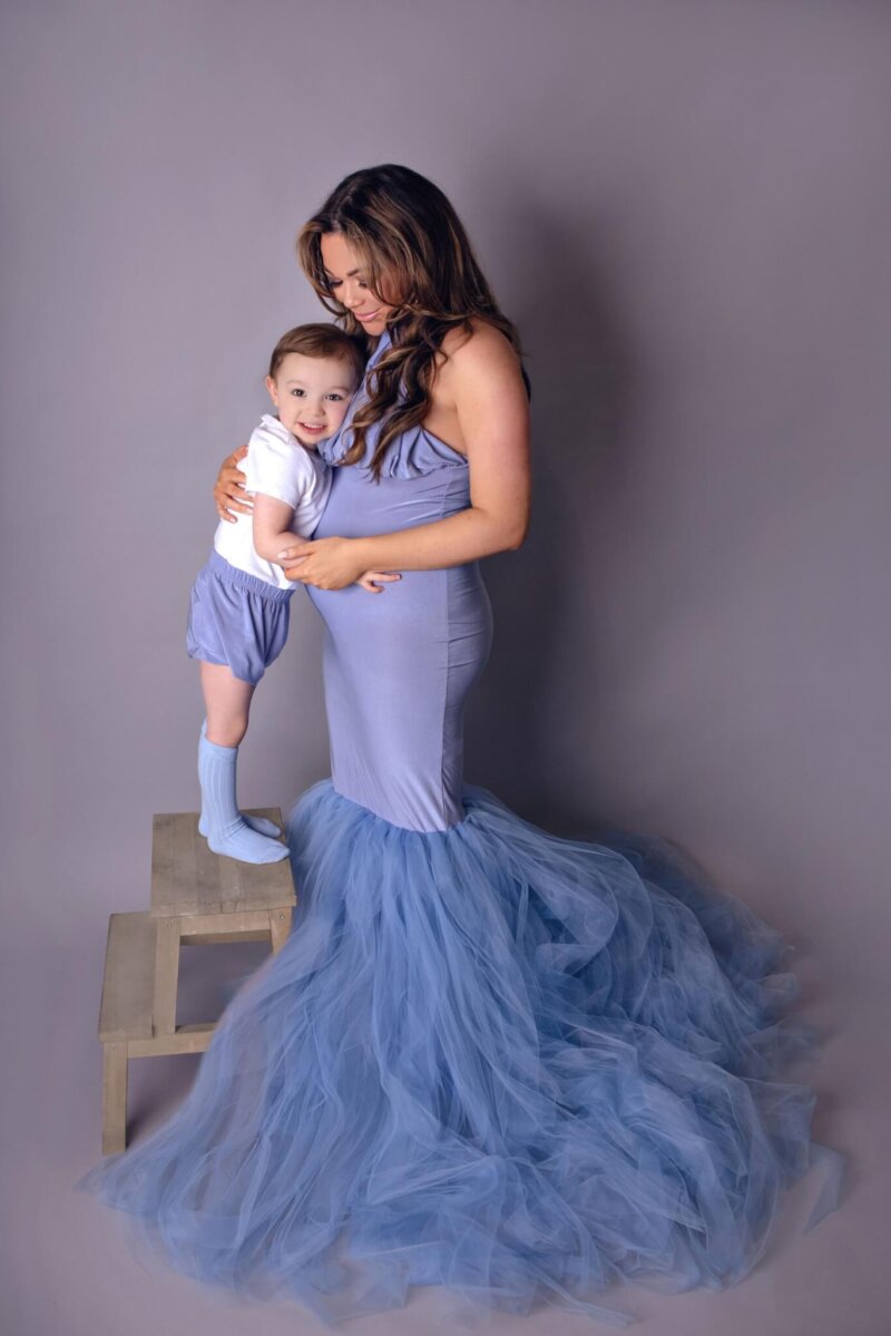 Boy hugging mother wearing boys shorts that to the mothers dress