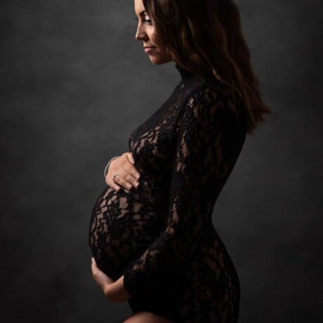 pregnant woman facing left wearing black bodysuit by rosa amour